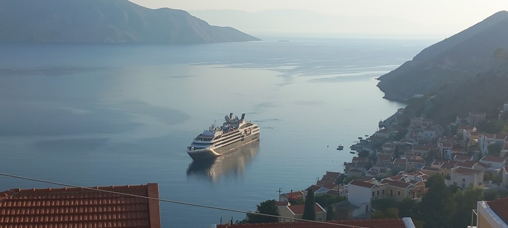 A cruise ship emerges from the early-morning humidity haze